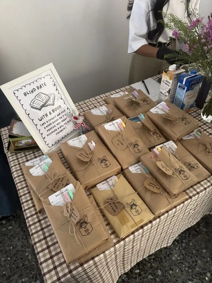 Books wrapped in kraft paper with handwritten tags, laid out on a checked tablecloth ready to swap
