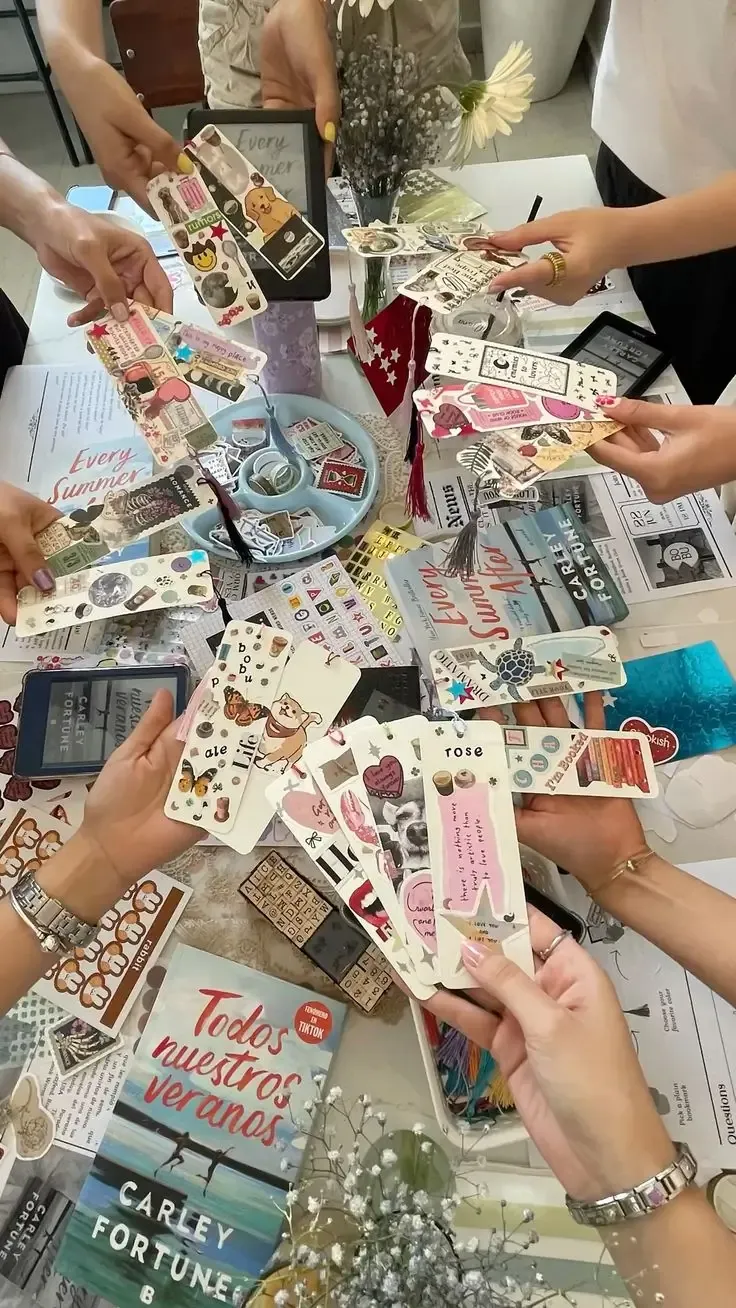 Hands holding handmade bookmarks decorated with stickers