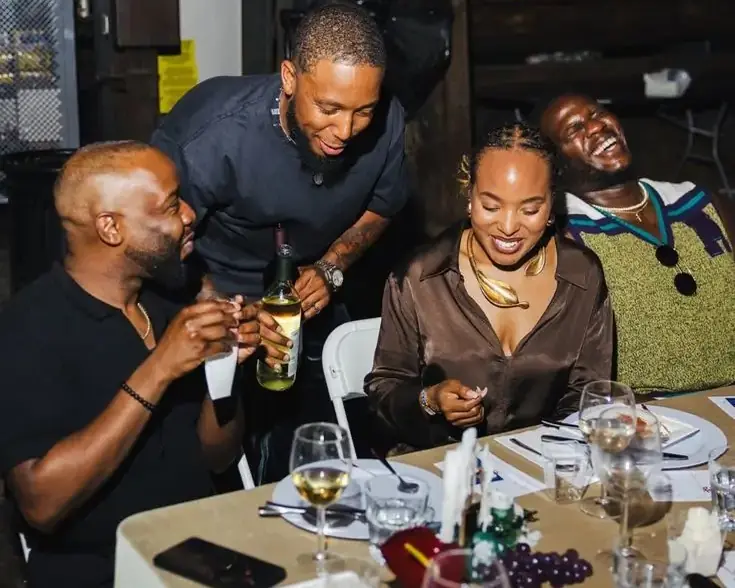 Friends laughing around a restaurant table at night